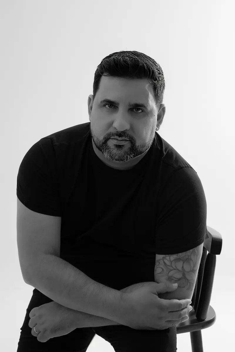 Verlano Alves in black and white, leaning on a chair