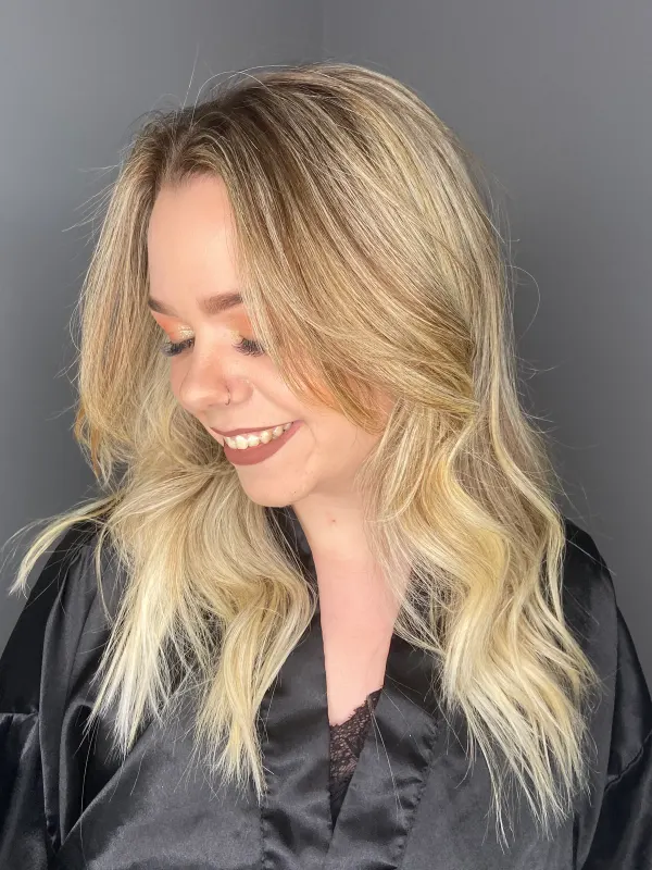 Soft blonde waves left undone, cut to fall around the face
