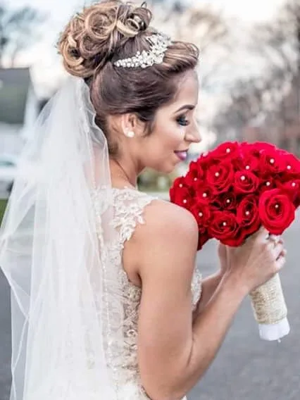 High bridal bun with a pearl comb, worn with a veil
