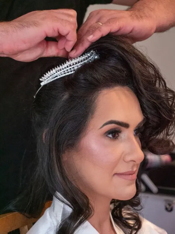 A tiara comb being set into the finished bridal hair