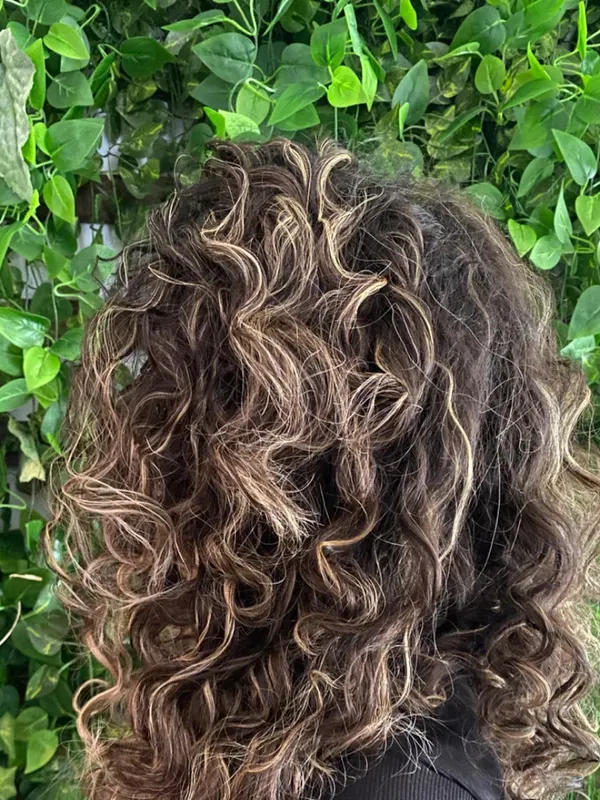 Natural curls cut for volume, with highlights placed to follow the curl pattern